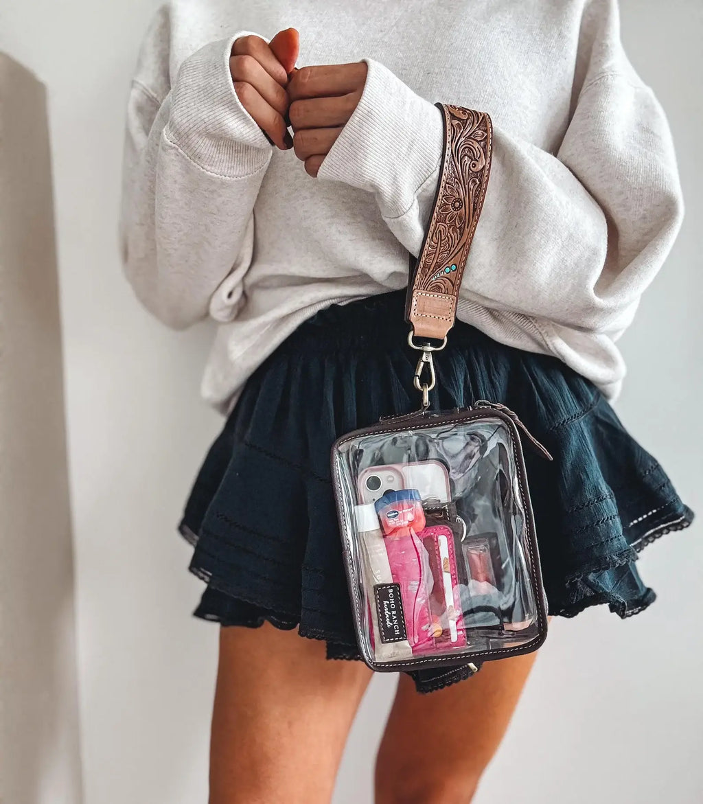 DARLA CLEAR WRISTLET | transparent western purse - game day held by a woman in a cozy outfit.