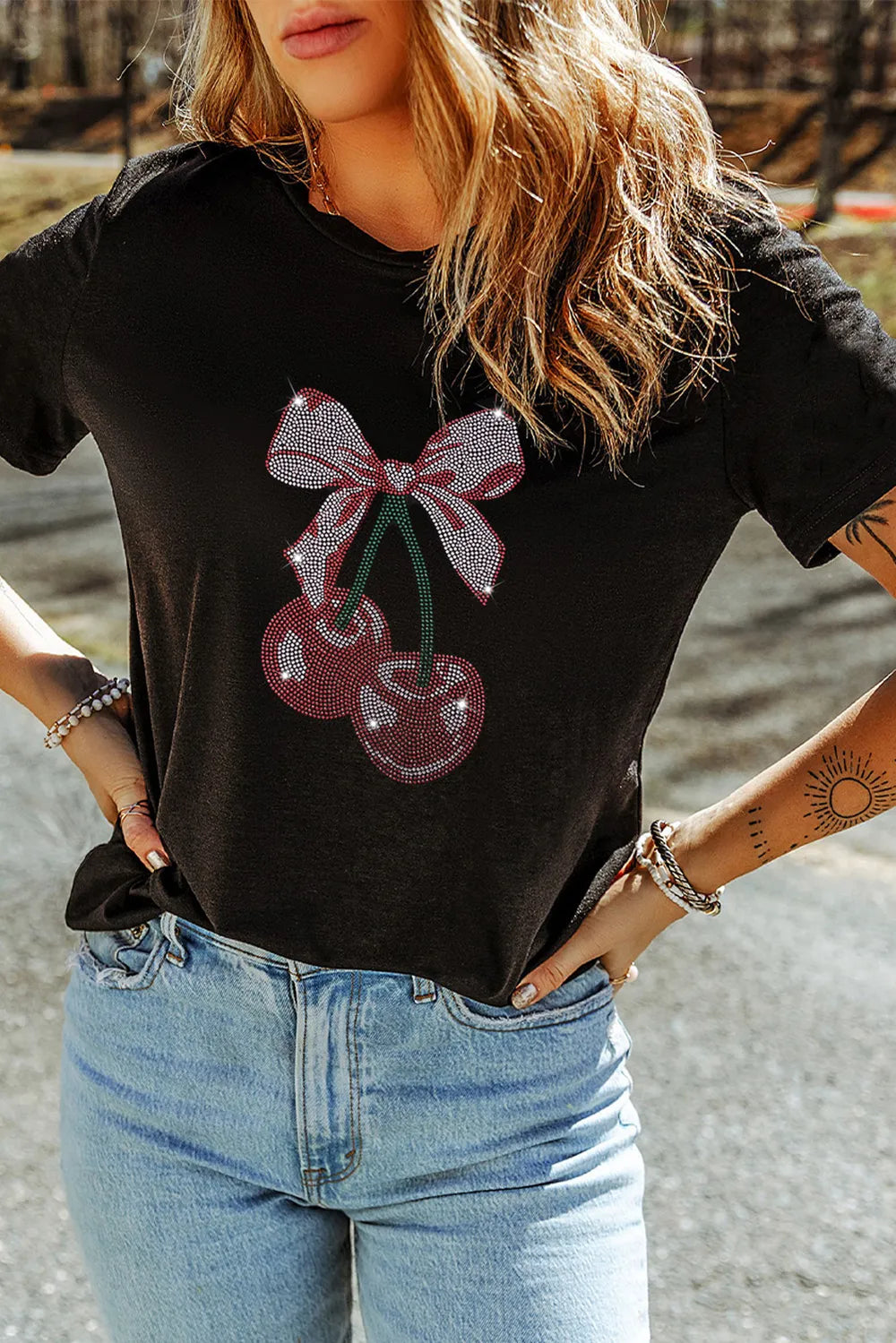 Cherry Graphic Round Neck Short Sleeve T-Shirt featuring a cherry and bow design on a black background.
