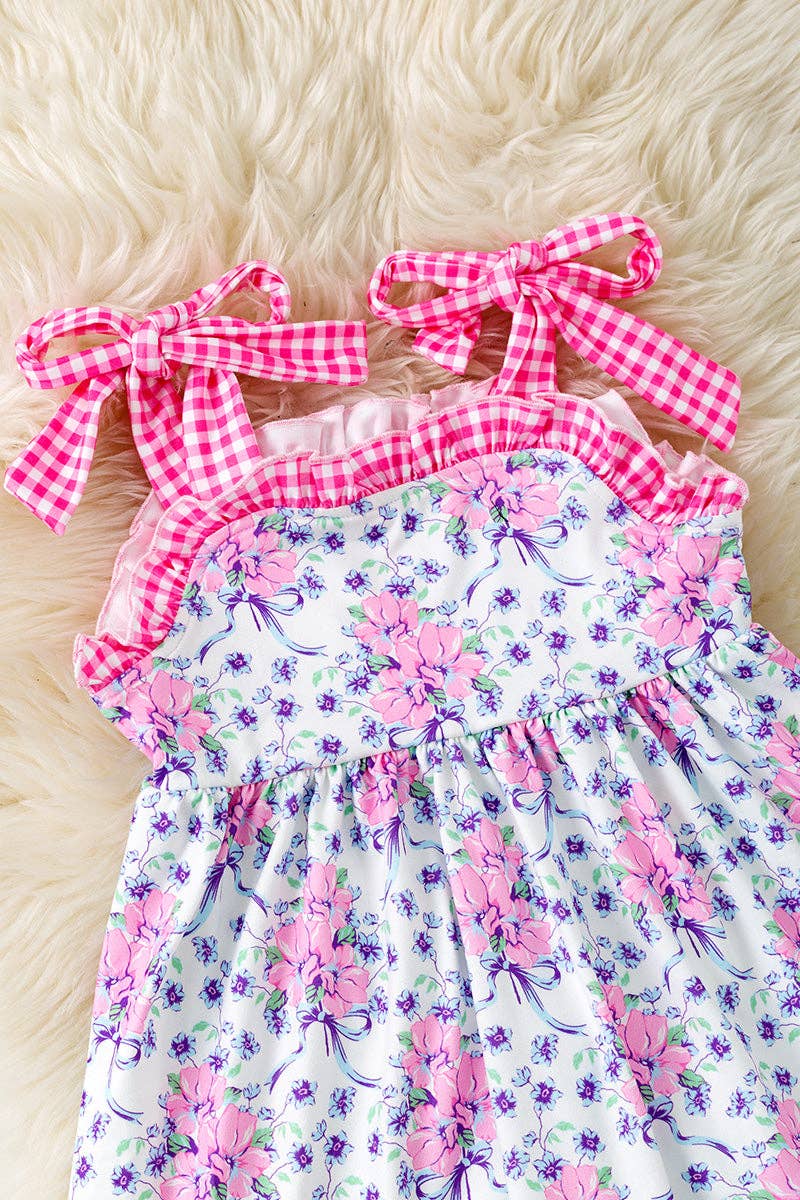 Purple/pink floral tunic with gingham straps and blue shorts.