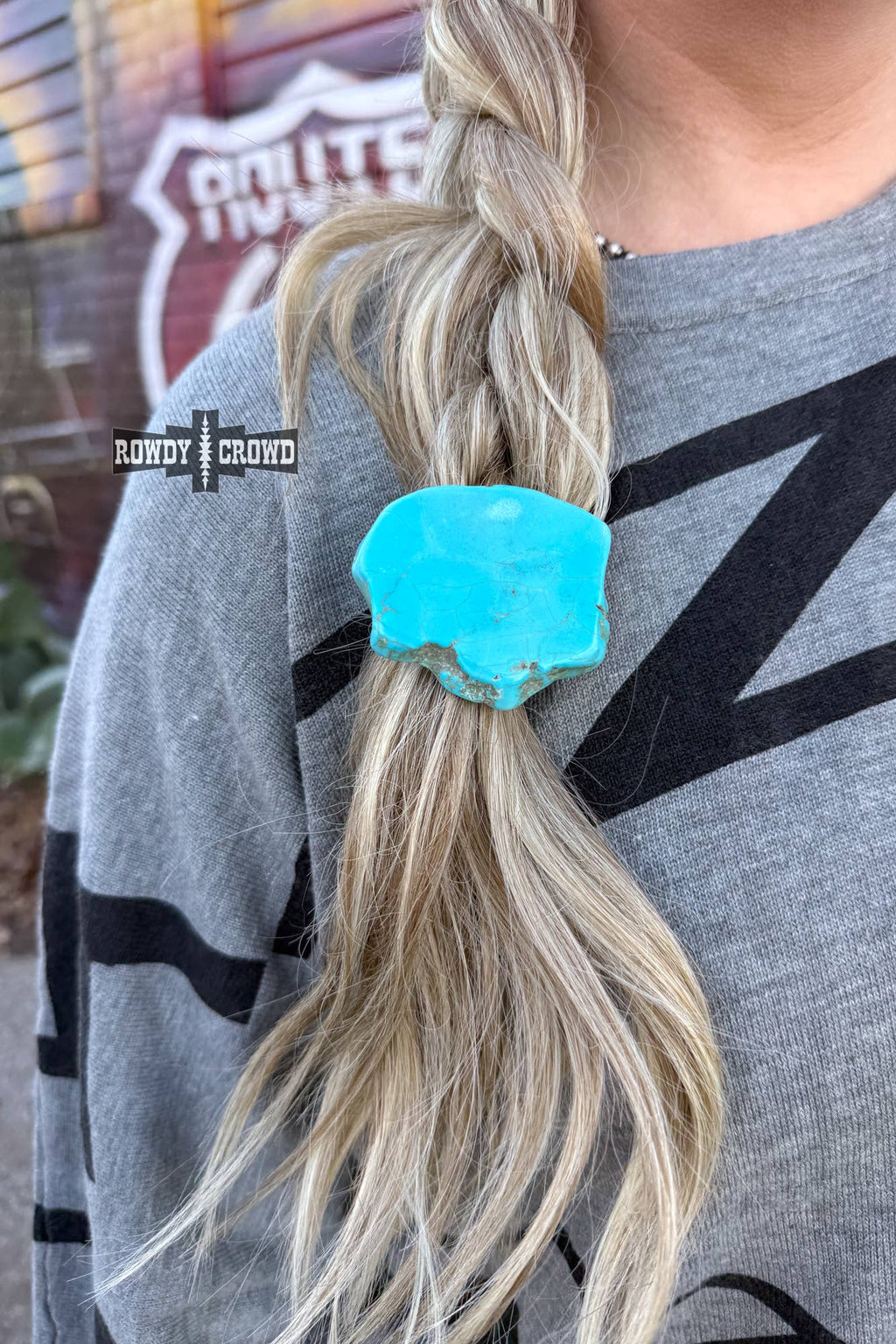 Turquoise Rock Ponytail Holder in a braided hairstyle, highlighting the vibrant turquoise color and unique rock design.