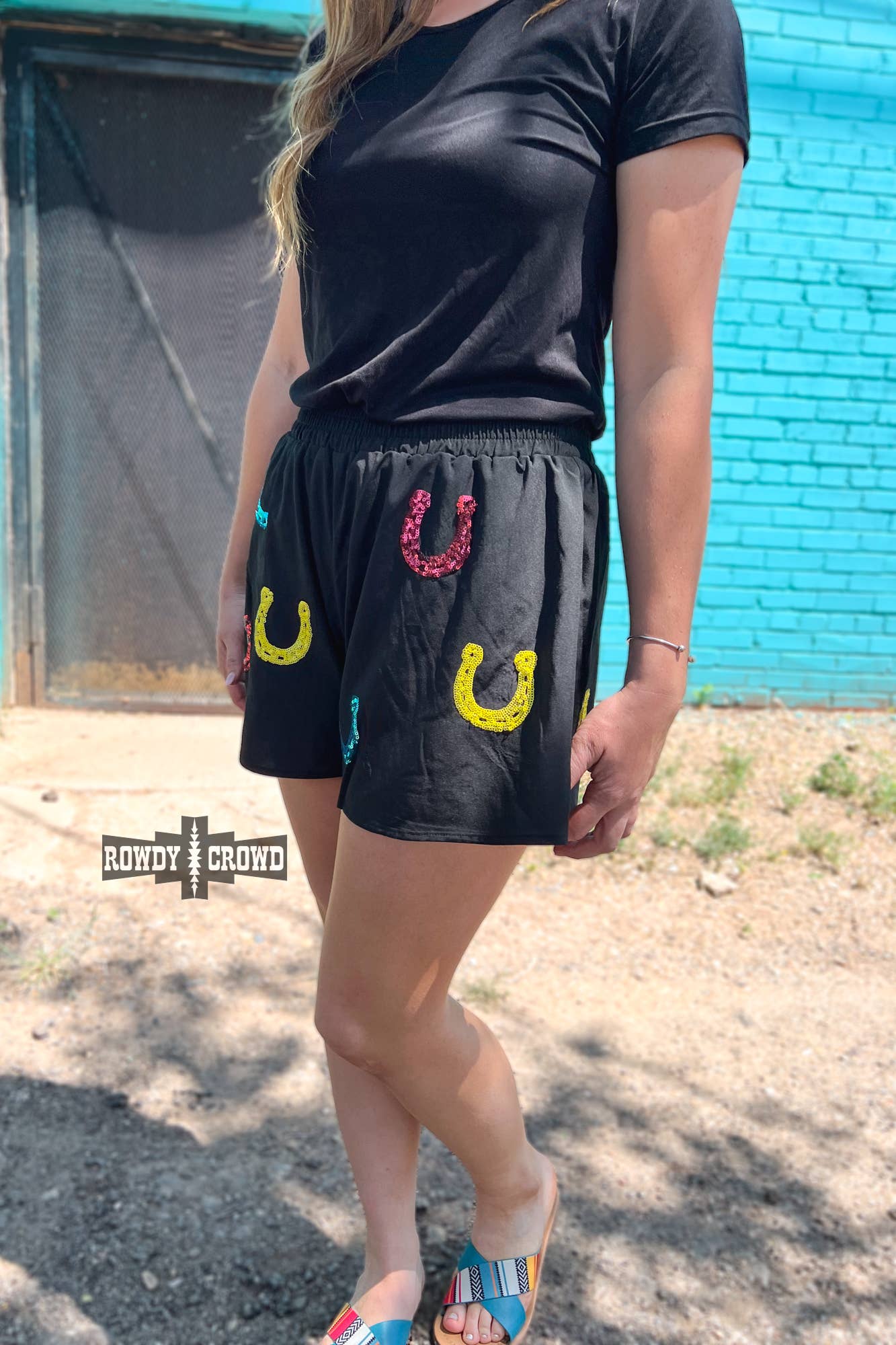 Lucky Buck Shorts featured with vibrant sequin horseshoes in yellow, red, and turquoise on a model.